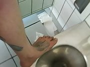 Barefoot on a filthy public toilet and tapping some piss