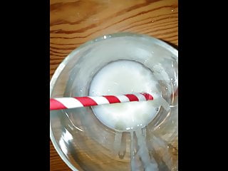 Big cumshot into a glass with a straw