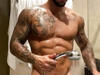 Tattooed muscle stud washing his massive...