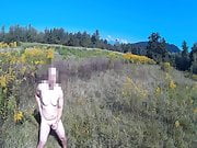 Naked guy masturbating in open field