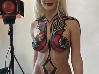 Naked blonde getting body painted